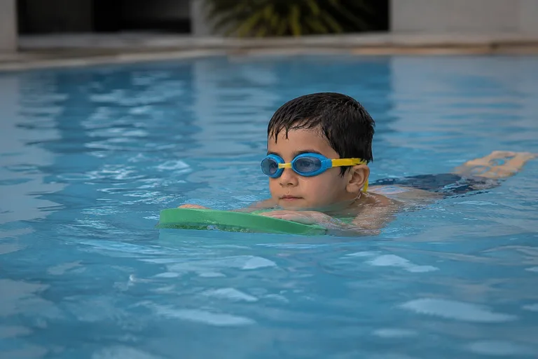 A child swimming calmly with a practice float